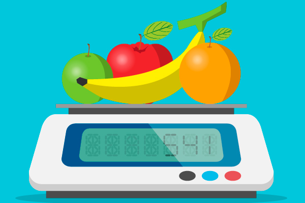 Dos manzanas, una banana y una naranja sobre una balanza