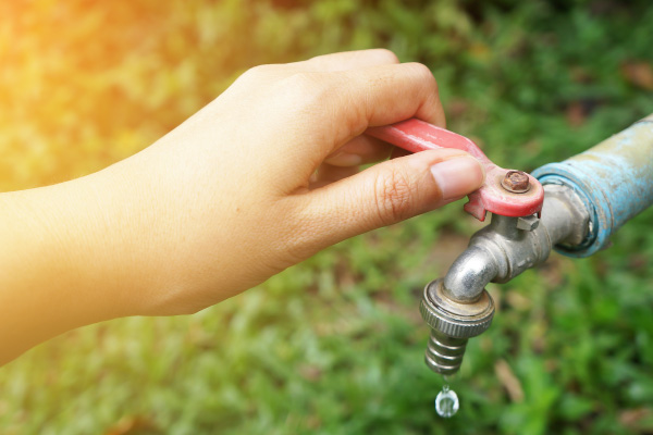 Mano abriendo canilla de agua