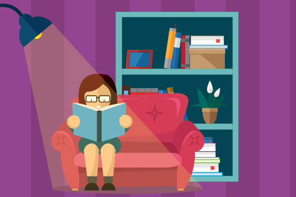 Niña leyendo libro a la luz de una lámpara.
